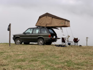 A scenic campsite by a tranquil lake with mountains in the background, perfect for car camping.